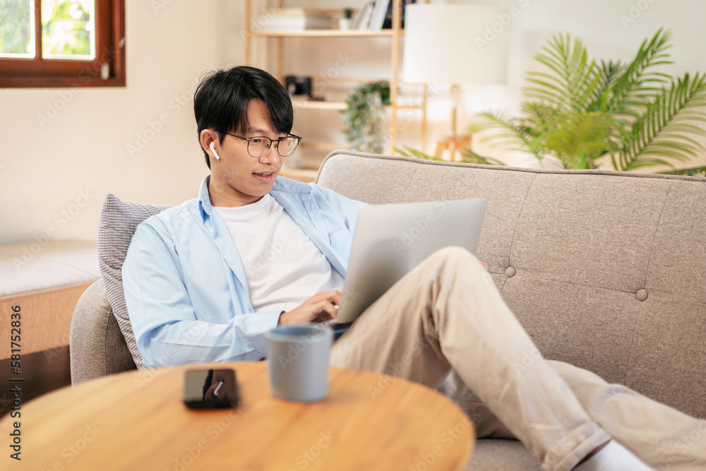 Businessman in casual is lying on comfortable sofa and wearing h Businessman in casual is lying on comfortable sofa and wearing h
