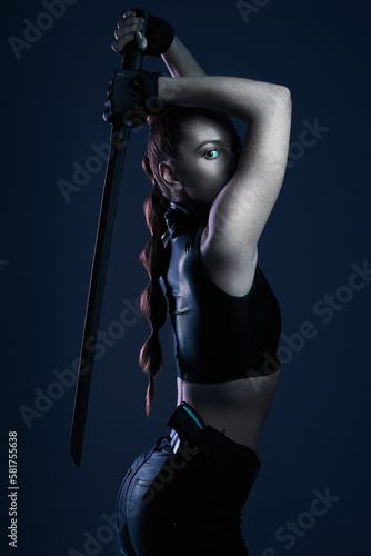 Fighter, dark and portrait of woman with a weapon isolated on a black background in a studio. Mystery, superhero and an assassin, ninja or girl doing cosplay, warrior fashion and acting on a backdrop