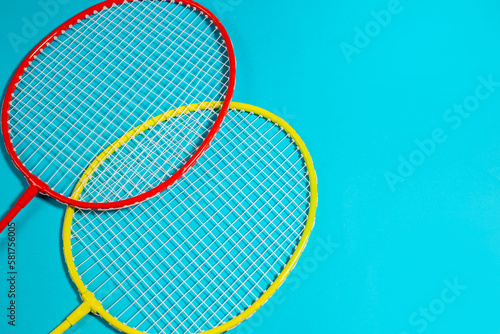 Two badminton  rackets and shuttlecock on blue background, copy space, space for text, top view © Yelena