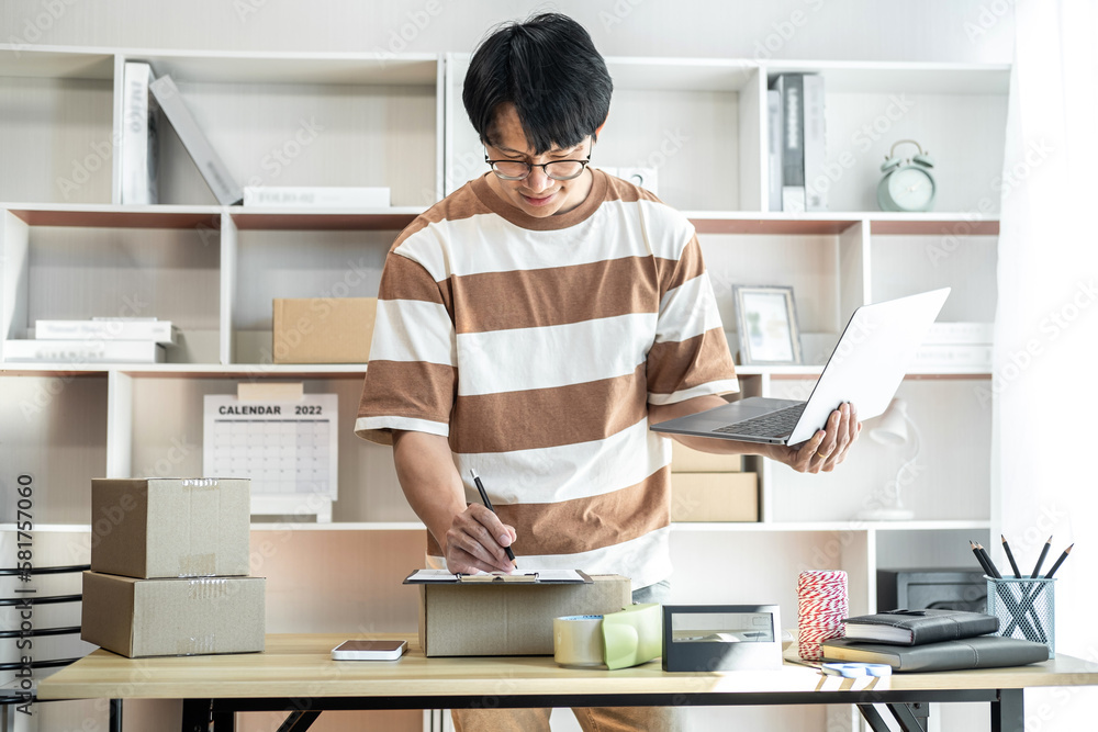 Male entrepreneur is checking and taking receive online orders o Male entrepreneur is checking and taking receive online orders o