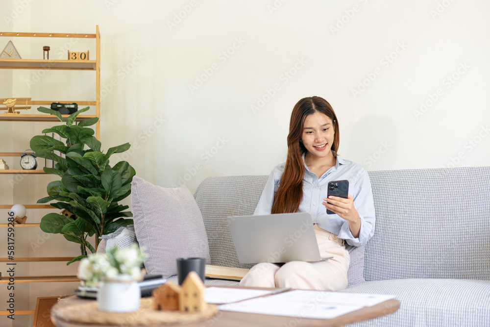 Female freelance is reading business data on smartphone and typi Female freelance is reading business data on smartphone and typi