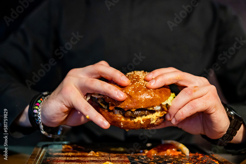 man hands hold fast food burger in pub
