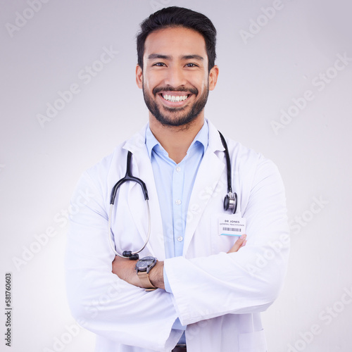 Doctor, man with arms crossed in portrait and smile, health and medical professional on studio background. Male physician, cardiovascular surgeon with stethoscope, happiness in medicine and mockup