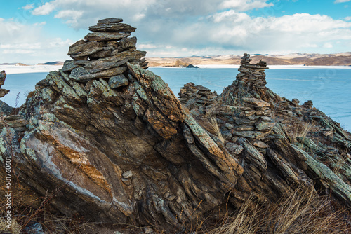 BAIKAL LAKE, RUSSIA-MARCH 1,2023: Pyramids of stones built on the shores of Lake Baikal.