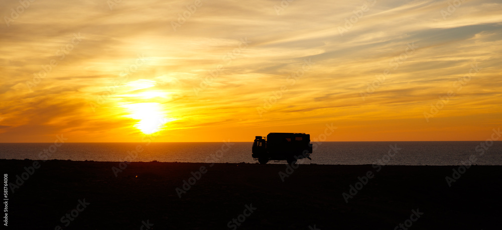 Fototapeta premium Adventurous road trip in motor home truck- sunset at the beach