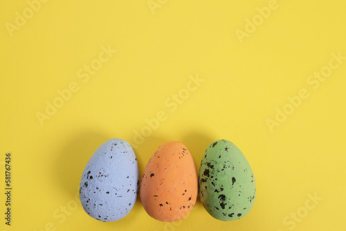 Decorative Easter eggs in a row on a yellow background