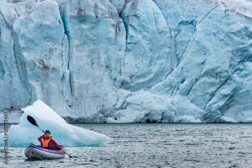 Young Woman Kayaking Mosevatnet Lake with Folgefonna Glacier in the background, Visiting Norway 