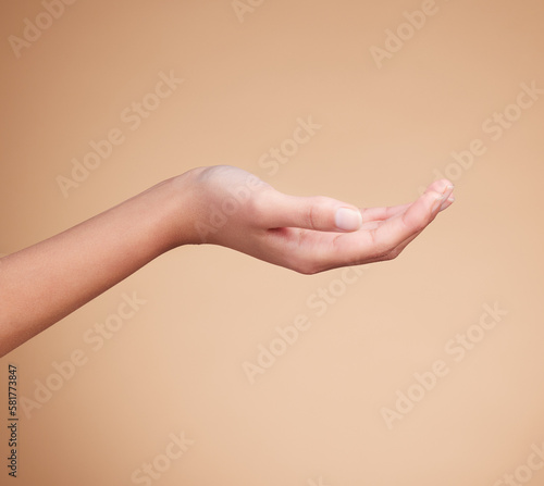 Hands, palm and product placement for mockup in studio isolated on a brown background. Skincare, dermatology and woman model with hand out for marketing, advertising or branding space for mock up.