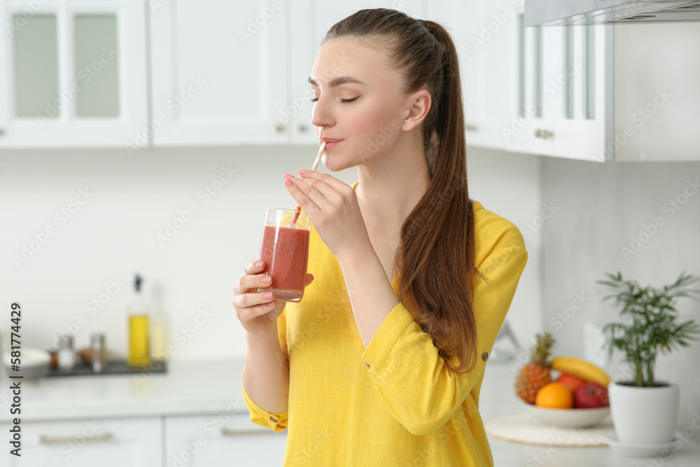 Beautiful young woman drinking delicious smoothie in kitchen Beautiful young woman drinking delicious smoothie in kitchen