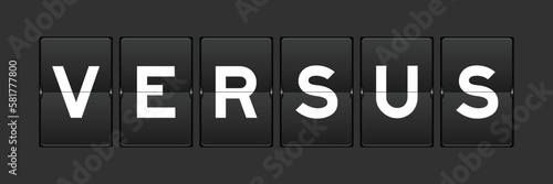 Black color analog flip board with word versus on gray background
