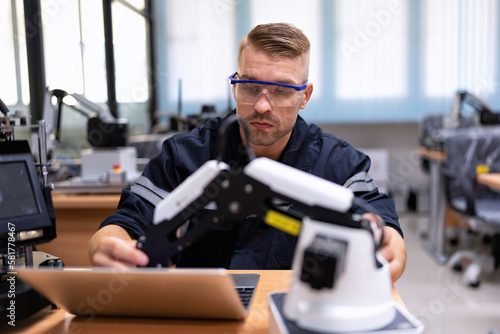 Engineer sitting in robot fab. room use laptop quality check and detail design engineering