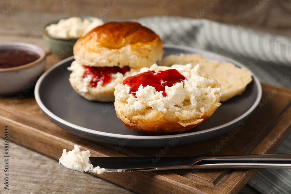 Freshly baked soda water scones with cranberry jam and butter on wooden table, closeup Freshly baked soda water scones with cranberry jam and butter on wooden table, closeup