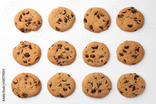 Many delicious chocolate chip cookies on white background, flat lay