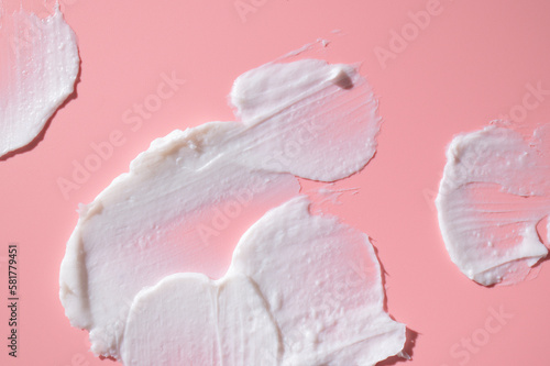 Cosmetics texture. Smear of white face or body cream, lotion, mousse, soap, shower gel on pink background. Spa, skin care, beauty and health, medicine. Cosmetic background, mockup