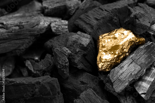 Shiny gold nugget on coals, closeup view