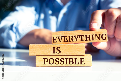 Close up on businessman holding a wooden block with "Everything is Possible" message