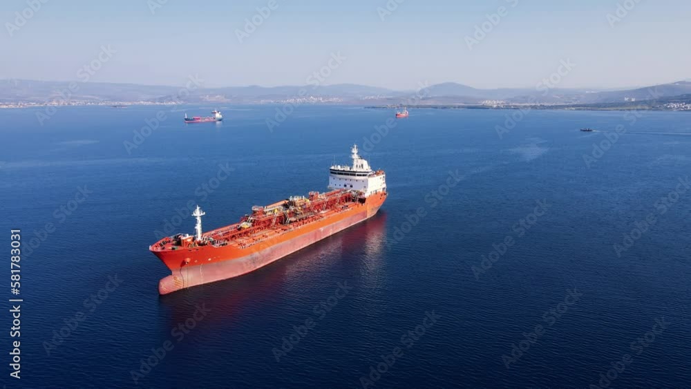 Aerial wide shot of industrial crude oil fuel tanker ship anchored in deep blue Aerial wide shot of industrial crude oil fuel tanker ship anchored in deep blue