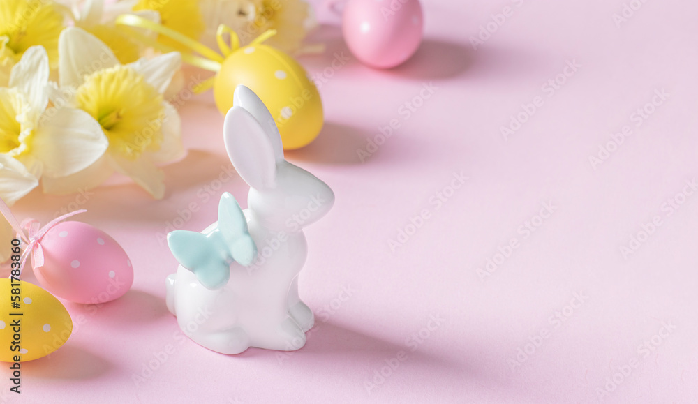 Easter bunny, daffodils, pink and yellow eggs on a pink background. Copy space Easter bunny, daffodils, pink and yellow eggs on a pink background. Copy space