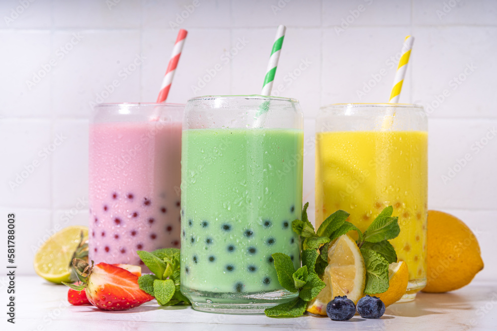 Set of three colorful summer bubble tea, bright creamy pearl tea or latte tapioca drinks, pink berry, yellow citrus, green mint, with tapioca balls and crushed ice, on white background Set of three colorful summer bubble tea, bright creamy pearl tea or latte tapioca drinks, pink berry, yellow citrus, green mint, with tapioca balls and crushed ice, on white background