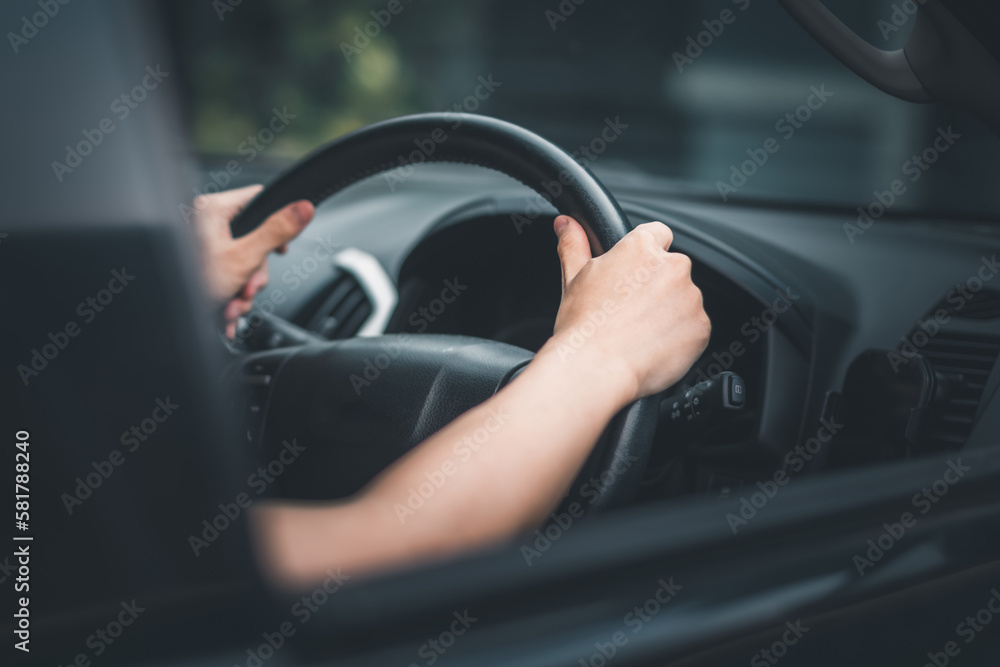Asian man hand holding steering wheel.