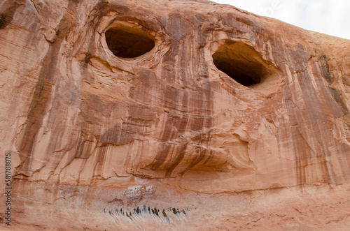 Steep wall with holes that look like eyes in Moab, Utah, USA.