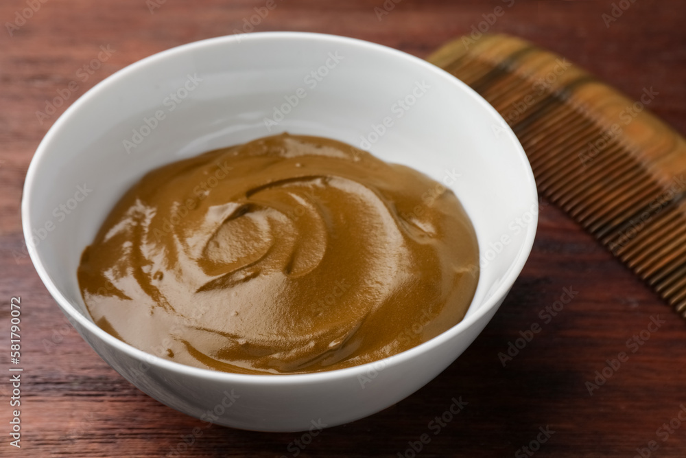 Bowl of henna cream on wooden table, closeup. Natural hair coloring Bowl of henna cream on wooden table, closeup. Natural hair coloring