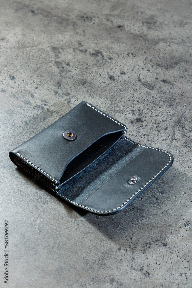 Black leather cardholder on a gray background. Handmade leather products. Black leather cardholder on a gray background. Handmade leather products.