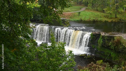 Waterfall with roaring and foaming water in Keila Joa park in autumn.