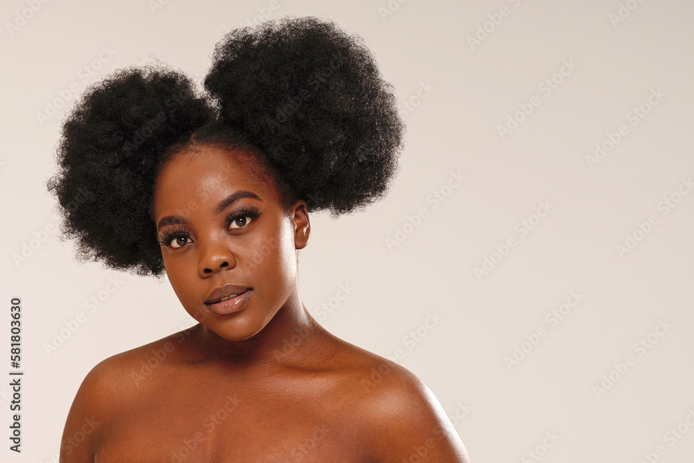 Beauty portrait of attractive woman with afro hair looking at the camera. Girl with long lashes and delicate makeup