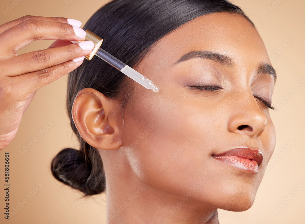 Woman, dropper and retinol on face for skincare beauty or cosmetics against studio background. Calm beautiful female model applying oil drop to skin for hydration, moisturizer or facial treatment Woman, dropper and retinol on face for skincare beauty or cosmetics against studio background. Calm beautiful female model applying oil drop to skin for hydration, moisturizer or facial treatment