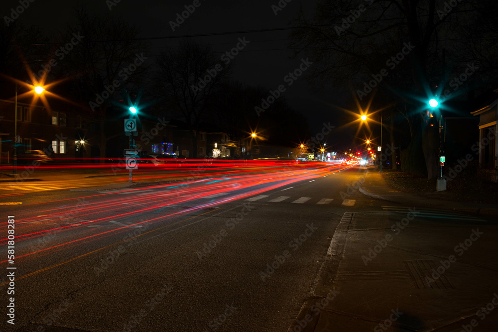 Boulevard in Montreal, Canada, at night with a lot of passing cars that leave a tray of light