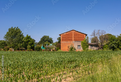 Baked brick half-timbered barn on farms in Tuscany region, nean Capannori, Lucca province,central Italy with window made of herringbone tiles for ventilation. the facade of a stone house in Tuscany.