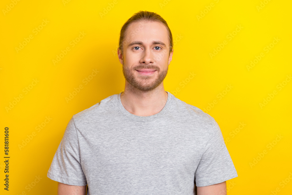 Obraz premium Photo of confident charming man wear grey t-shirt smiling isolated yellow color background