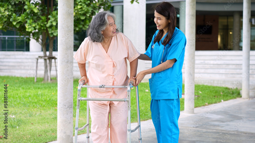 Asian careful caregiver or nurse taking care of the elderly Asian patient in a wheelchair. Concept of happy retirement with care from a caregiver and Savings and senior health insurance. elderly care