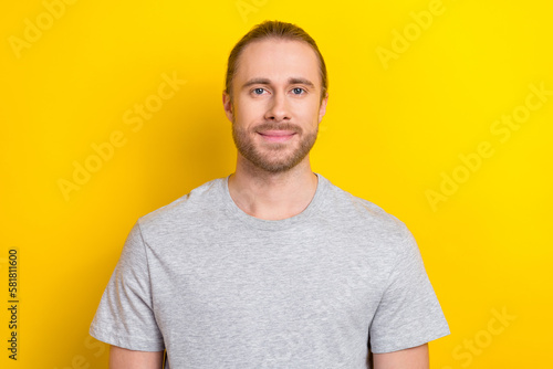 Photo of confident charming man wear grey t-shirt smiling isolated yellow color background
