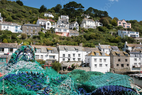 Fishing nets dry in the sun on the harbour wall at the pretty fishing village of Polperro, Cornwall, UK photo