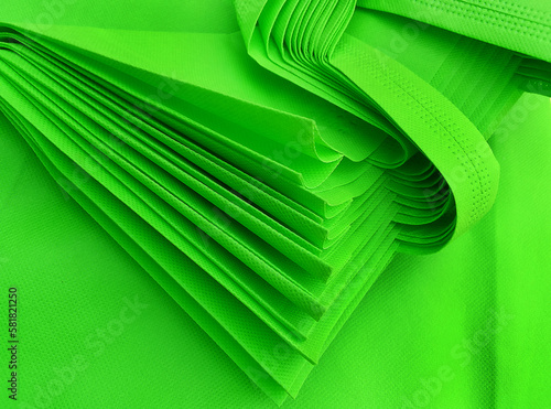 pile of green porous tote bags. non-woven fabric material. polypropyline bag