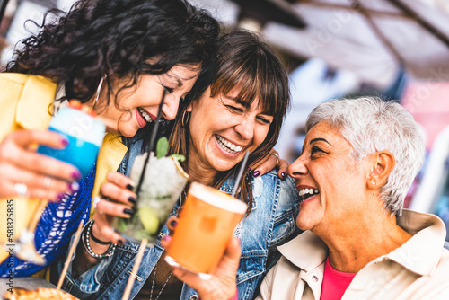 Group of happy mature female drinking and toasting cocktails together outdoors at bar terrace-Three senior people enjoying happy hour at restaurant with drinks - Lifestyle Elderly Concept with women
