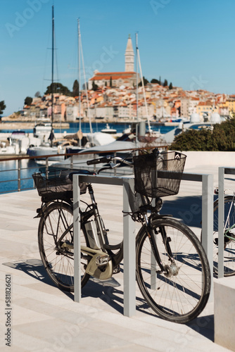 Historic cityscape of Croatian Mediterranean sea coast - old town Rovinj, boats on water and bike for ride in Istria Croatia