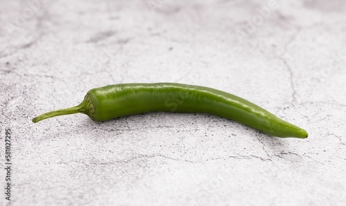 Closeup of a fresh jalapeno pepper on a white table