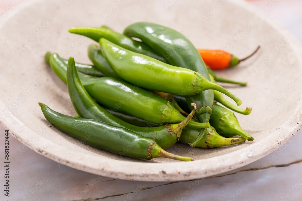Closeup of fresh jalapeno peppers on a white table Closeup of fresh jalapeno peppers on a white table