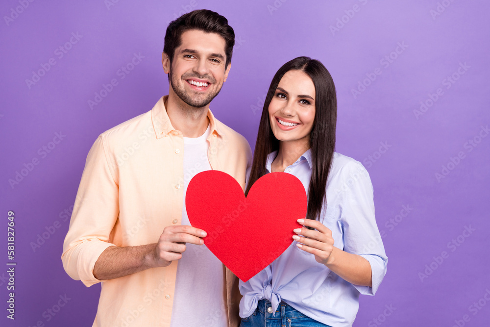 Photo of pretty cute couple wife husband together hold red paper big symbol celebrate anniversary valentine day isolated on purple color background