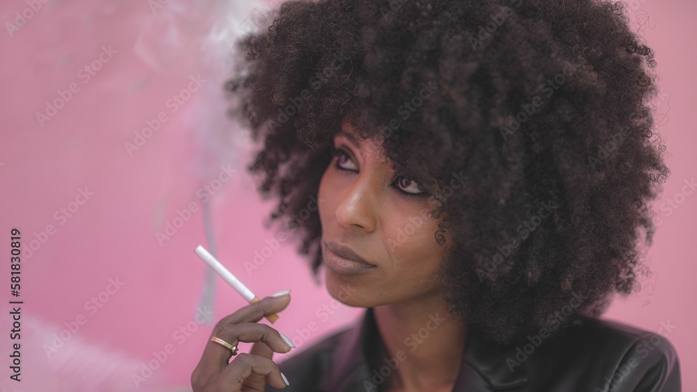 Fototapeta premium Young attractive African woman with happy cheerful smile smoking in a studio