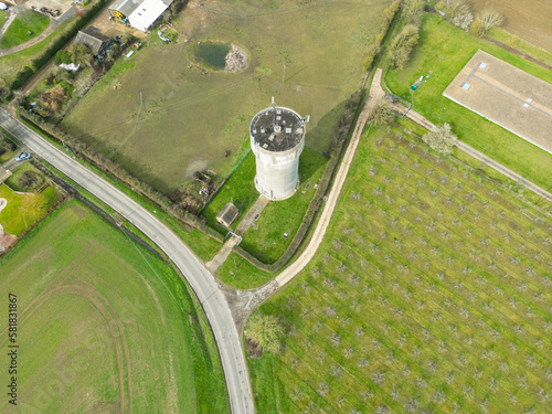 Fotomurale Aerial top down view of a tall concrete water tower showing an array of 4G and 5G radio masts