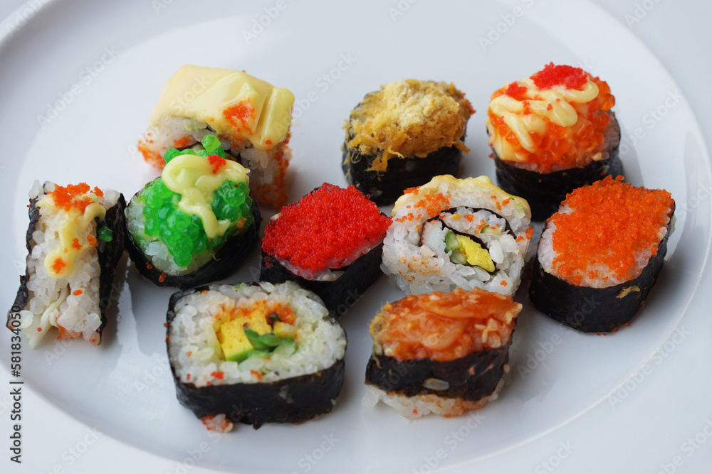 Colorful homemade sushi rolls on white plate. Variety topping. Concept, Traditional Japanese food. Cuisine, culture eating lifestyle. Favorite street food in Thailand. Colorful homemade sushi rolls on white plate. Variety topping. Concept, Traditional Japanese food. Cuisine, culture eating lifestyle. Favorite street food in Thailand.