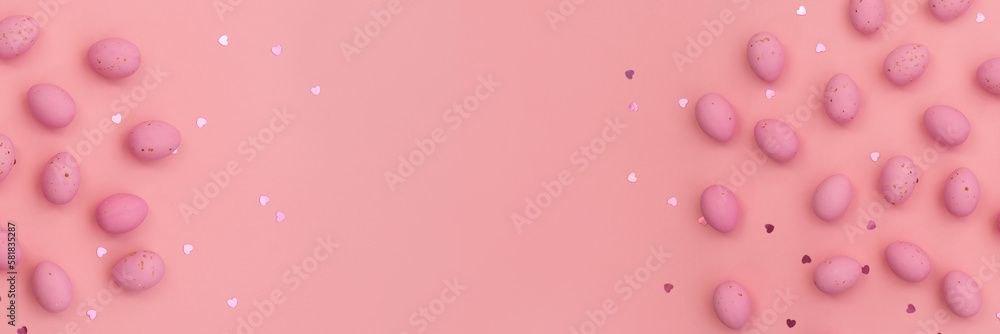 Banner made from Easter pink chocolate eggs on pastel pink background. Shimmering glowing hearts. Minimalist composition. Use in marketing materials, decorative element in variety of contexts