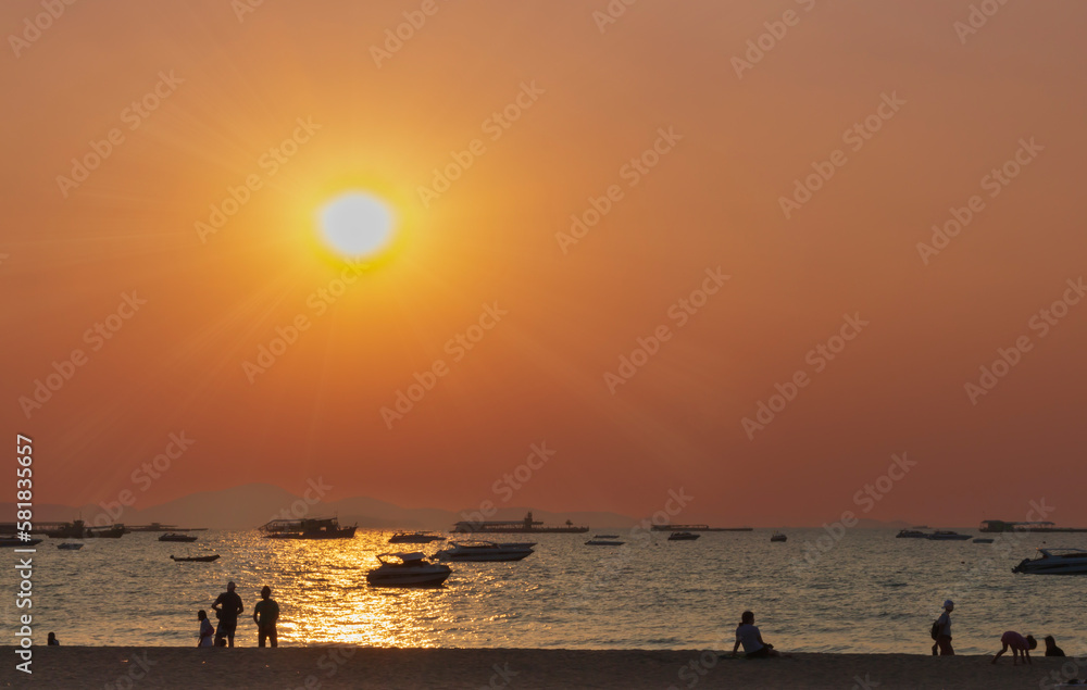 group of people on sandy beach in various poses and meets sunset on sea.Evening,Silhouettes,Thailand