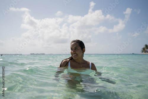 Beautiful tan Colombian women enjoying crystal water on Caribbean island in San Blas