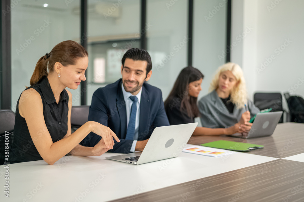 Group of coworkers in formal wear sitting at table in conference room. Business meeting team in office