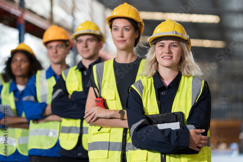 Group of warehouse workers standing with crossed arms in storage warehouse. Complete finish job. Successful of work concept